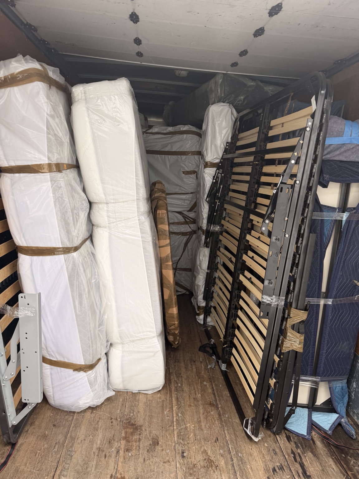 Furniture and bed frames carefully arranged inside a moving truck